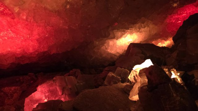 Blick in die funkelnde Kristallgrotte des Erlebnis-Bergwerks Merkers mit rot und wei&szlig; leuchtenden Salzkristallen.