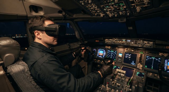 Ein Pilotensitz in einem modernen Cockpit mit VR-Headset und VR-Controllern auf der Konsole.