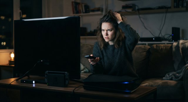 Frustrierter Nutzer vor einem Fernseher mit technischer Fehlermeldung